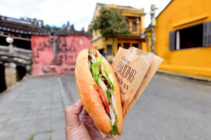 Nếu bạn đến Hội An mà chưa thử bánh mì ở đây, thì chuyến đi vẫn chưa trọn vẹn! Quán bánh mì trứ danh này chinh phục thực khách với hơn 20 loại nhân phong phú – từ thập cẩm, pate béo ngậy, thịt bò cuộn phô mai tan chảy đến thịt xông khói đậm đà… tha hồ chọn lựa theo khẩu vị riêng. Bánh mì nóng giòn vừa ra lò, lớp vỏ giòn tan kết hợp hoàn hảo cùng phần nhân thơm lừng, đậm vị khiến ai thử qua một lần cũng khó quên.