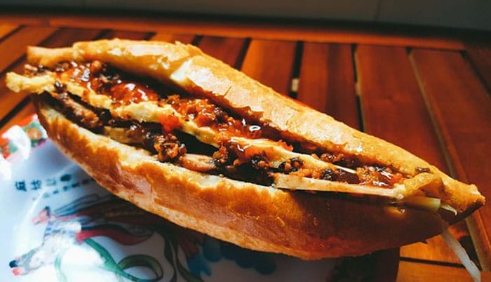 Bánh mì cô Ngọc là điểm dừng chân thân quen không chỉ với người dân địa phương mà còn “đốn tim” cả những tín đồ mê ẩm thực đường phố khi ghé thăm phố cổ. Dù không quá nổi đình nổi đám như nhiều quán khác, nhưng hương vị đậm đà cùng mức giá vô cùng “hạt dẻ” lại chính là lý do khiến quán luôn được lòng du khách gần xa. 