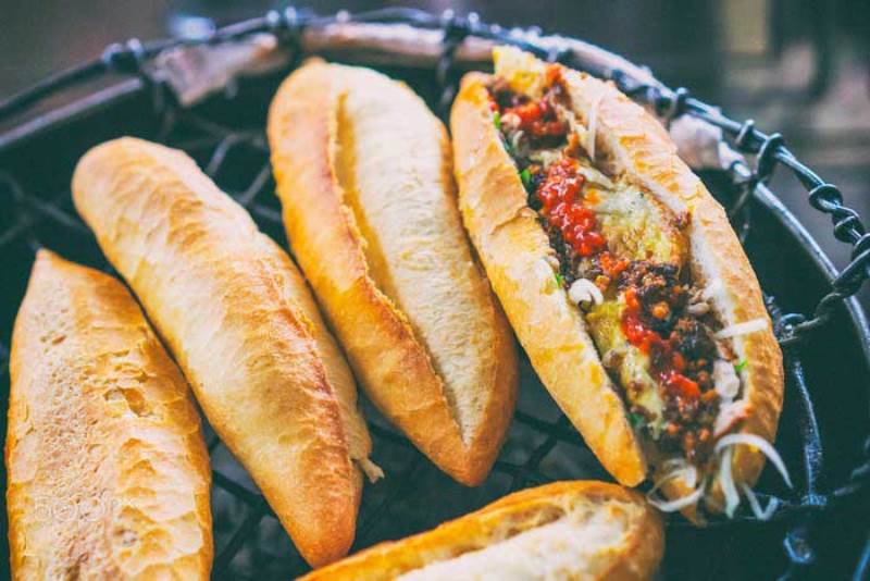 Là một trong những quán bánh mì lâu đời ở Hội An, bánh mì cô Lành mang đến hương vị mộc mạc nhưng đầy cuốn hút khiến bao thực khách say mê. Bánh được nướng trực tiếp trên bếp than hồng, tạo lớp vỏ giòn rụm đặc trưng, thơm phức ngay từ khi còn trên lò. Không gian quán nhỏ xinh, đơn sơ giữa lòng phố cổ lại chính là điểm cộng khiến ai từng ghé qua đều cảm nhận được sự yên bình, gần gũi rất Hội An. Đặc biệt, chỉ với 10.000 VNĐ, bạn đã có thể thưởng thức một chiếc bánh mì thơm ngon, đầy đặn – món quà giản dị mà khó quên của phố Hội.