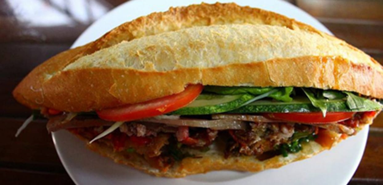 Điều làm nên sức hút đặc biệt của bánh mì Sum chính là phần nhân chất lượng, được chế biến theo công thức gia truyền chuẩn vị người Hội An. Mỗi ổ bánh mì ở đây là sự kết hợp tinh tế giữa các loại topping như: thịt chả đậm đà, thịt xíu mềm thơm, gà xé dai ngon, thịt heo kho trứng béo ngậy, thịt nướng thơm lừng, trứng ốp la béo mịn, cá khô mằn mặn và xúc xích hấp dẫn. Tất cả được gói gọn trong lớp vỏ bánh giòn rụm, nóng hổi, mang đến trải nghiệm vị giác trọn vẹn và khó quên. Chỉ cần một lần nếm thử, bạn sẽ hiểu vì sao bánh mì Sum lại khiến bao người mê mẩn đến thế!