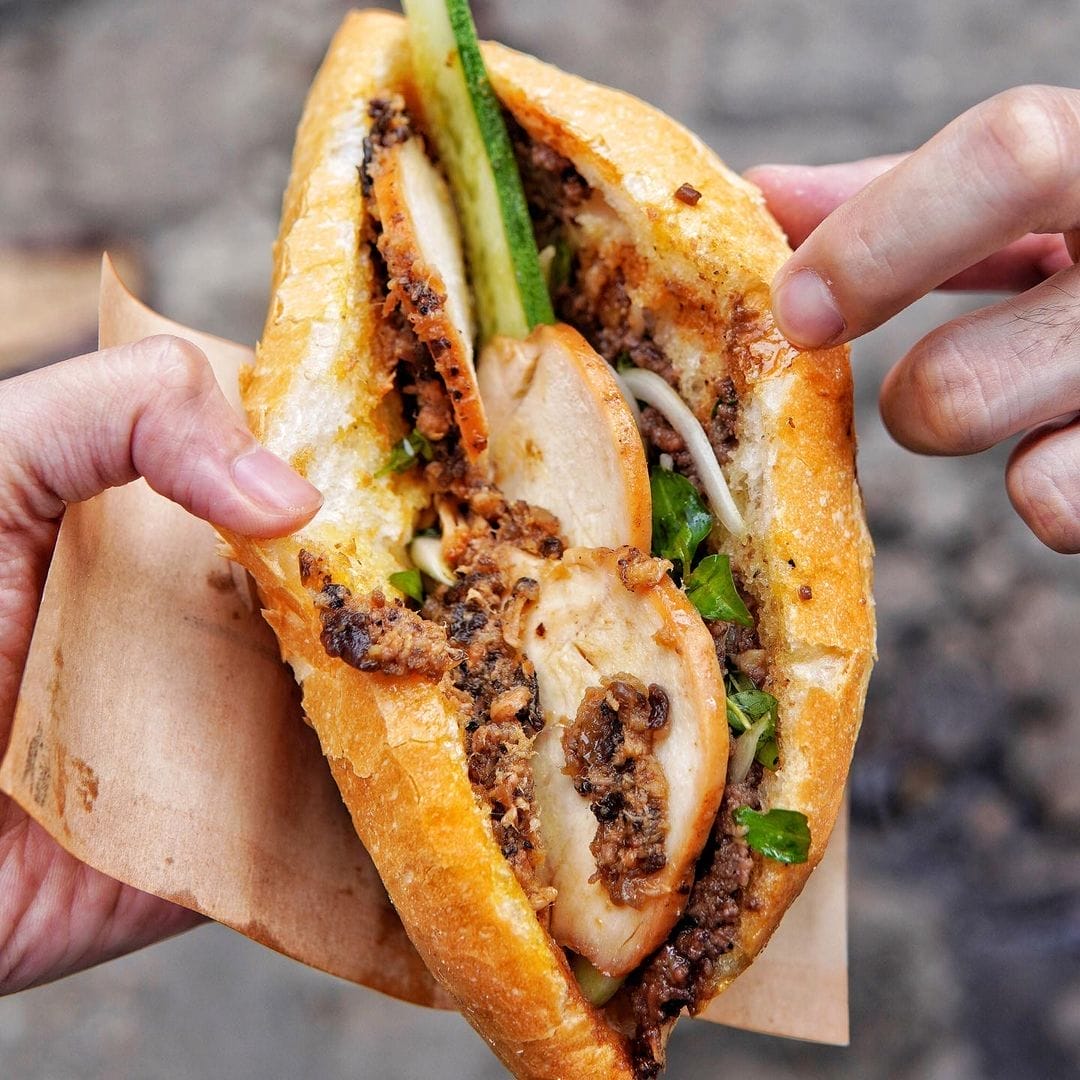 Chắc hẳn không phải ngẫu nhiên mà Madam Khánh được mệnh danh là “Nữ hoàng bánh mì” trên các trang báo quốc tế và trong lòng du khách gần xa. Mỗi ổ bánh mì tại đây là một tác phẩm đầy tâm huyết — từ lớp vỏ giòn tan được đặt riêng tại lò bánh uy tín, đến phần nhân đậm đà được chế biến theo công thức gia truyền bí mật. Từng nguyên liệu đều được chọn lọc và tẩm ướp tỉ mỉ, mang đến hương vị khó quên ngay từ lần đầu thưởng thức. Ghé Hội An mà bỏ lỡ bánh mì Madam Khánh, hẳn sẽ là một trong những điều tiếc nuối nhất trong hành trình khám phá ẩm thực phố Hội.