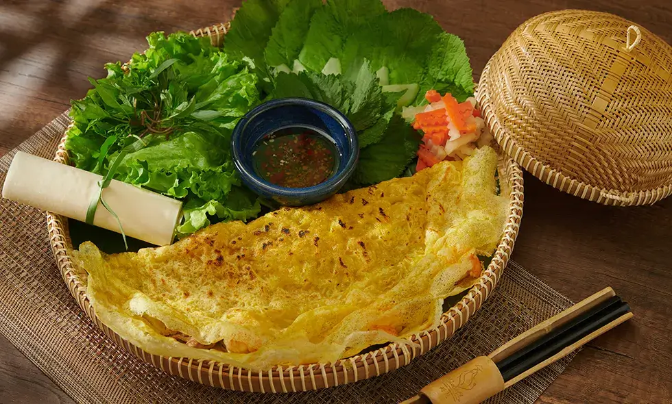 Nếu bạn là tín đồ của hương vị đậm đà miền Trung, thì bánh xèo Hải Sơn chắc chắn sẽ khiến bạn “phải lòng” ngay từ lần đầu thưởng thức. Bánh xèo tại đây nổi bật với lớp vỏ mỏng giòn rụm, ráo dầu, không hề gây ngấy. Nhân bánh gồm giá đỗ tươi và thịt thơm ngọt, hòa quyện trong từng miếng bánh nóng hổi – tất cả tạo nên một trải nghiệm trọn vẹn đậm chất Hội An mà bạn khó lòng quên được.