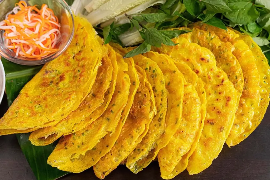 Nếu muốn thưởng thức bánh xèo Hội An đúng chuẩn, bạn nhất định phải ghé quán Giếng Bá Lễ – nơi nổi tiếng với món nước chấm "độc quyền" pha chế theo công thức gia truyền. Sự kết hợp độc đáo giữa đậu phộng bùi bùi và gan heo béo ngậy tạo nên hương vị đậm đà khó cưỡng, khiến ai nếm thử một lần cũng phải nhớ mãi.