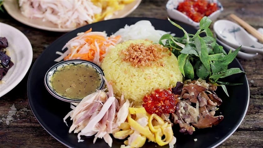 Một phần cơm gà tại quán được trình bày đẹp mắt, đầy đặn với phần cơm dẻo thơm tương đương khoảng một chén lớn. Thịt gà xé dai ngọt, trộn cùng hành tây và rau răm, rắc nhẹ chút muối tiêu để dậy mùi và tạo điểm nhấn hương vị đầy cuốn hút. Mỗi muỗng cơm hòa quyện vị bùi, cay, thơm khiến thực khách khó lòng dừng đũa.
