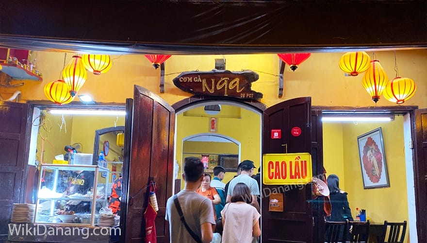 Quán Bà Nga ghi dấu ấn trong lòng thực khách với món cơm gà đậm vị, thịt gà mềm ngọt hòa quyện cùng nước sốt đặc chế, ăn kèm đa dạng rau tươi khiến bữa ăn thêm trọn vẹn. Không gian quán rộng rãi, thoáng đãng, nổi bật với tường vàng, cửa sổ xanh mang đậm hơi thở Hội An xưa – vừa ấm cúng, vừa là background tuyệt vời cho những bức ảnh check-in đầy chất thơ. Đây chắc chắn là quán cơm gà Hội An lý tưởng cho  những ai muốn thưởng thức đặc sản trong không gian đậm chất phố Hội.
