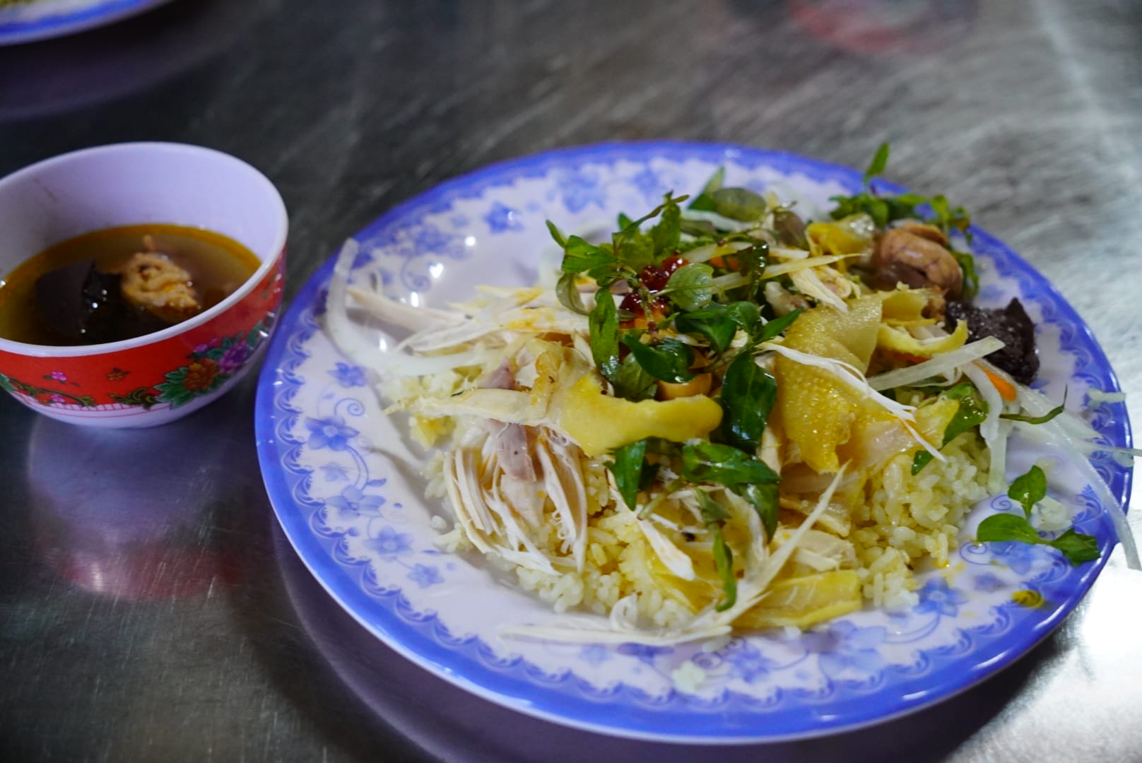 Đúng như tên gọi, quán mang một vẻ đẹp giản dị, đậm nét thôn quê Việt Nam. Không gian mộc mạc với bàn ghế gỗ truyền thống tạo cảm giác gần gũi, ấm cúng như trở về miền ký ức. Cơm được nấu bằng nước luộc gà nên dậy vị ngọt thanh, béo nhẹ, ăn kèm với thịt gà xé tơi, thấm đều gia vị đậm đà. Thêm vào đó, đội ngũ nhân viên phục vụ luôn thân thiện, tận tâm, khiến thực khách cảm thấy thoải mái và hài lòng từ lúc bước vào cho đến khi rời quán.