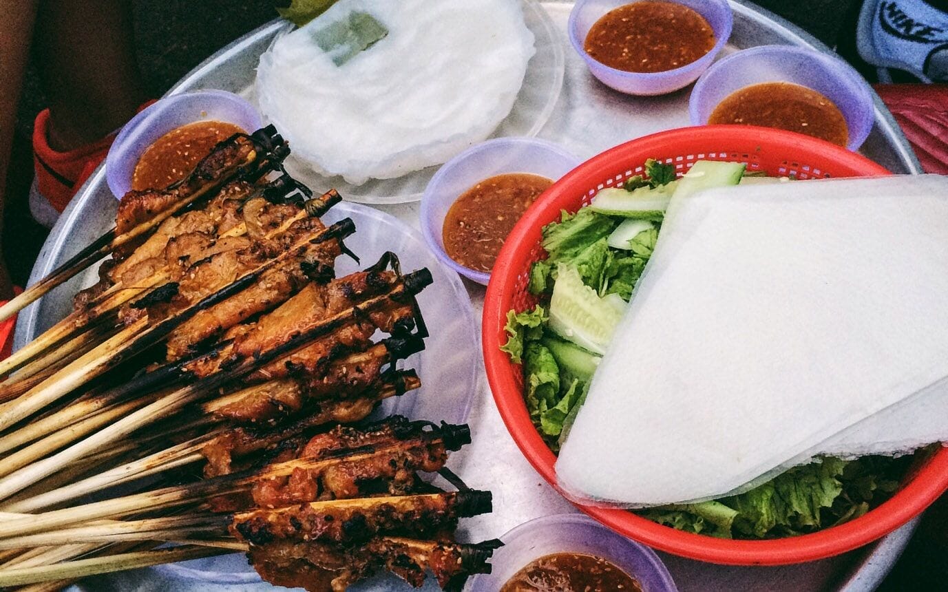 Quán bánh ướt thịt nướng Cô Xí ở Hội An ghi điểm không chỉ nhờ mức giá phải chăng mà còn bởi sự thân thiện, dễ mến của cô chủ quán. Mỗi xiên thịt được ướp khéo léo, thấm vị, nướng vàng thơm nức mũi. Điểm nhấn đặc biệt làm nên sự khác biệt chính là chén nước chấm "độc quyền" – sự hòa quyện tinh tế giữa mắm và tương, tạo nên hương vị lạ miệng khó quên, hiếm có ở những quán ăn vặt Hội An khác.