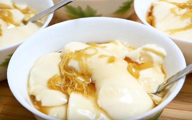 Chỉ là món ăn vỉa hè bình dị, thế nhưng tào phớ Hội An lại có sức hút lạ kỳ, khiến bao người ăn một lần là nhớ mãi. Từng viên tào phớ mềm mịn, thanh mát làm từ đậu tương xay nhuyễn, hòa quyện cùng đá bào mát lạnh, nước đường ngọt dịu và vài giọt cốt dừa béo ngậy. Mỗi muỗng là một sự ngây ngất – vị thanh đạm của đậu nành, cái ngọt nhẹ của đường, thoảng hương dừa thơm bùi, như một "bản giao hưởng" tinh tế đánh thức mọi giác quan.