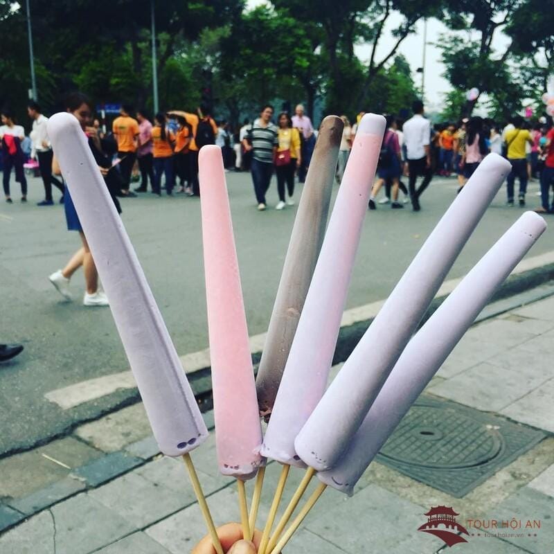 Đến Hội An mùa hè mà bỏ lỡ món kem ống mát lạnh thì quả là thiếu sót lớn! Những que kem rực rỡ sắc màu, vị ngọt thanh từ trái cây tươi hòa quyện cùng vị béo ngậy, dai mềm đặc trưng, chỉ với giá bình dân nhưng đủ khiến bạn "đổ gục" ngay từ lần đầu nếm thử. Món quà vặt dân dã này chính là cứu tinh xua tan cái nóng oi ả của mùa hè xứ Quảng.